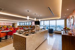 a restaurant with a counter with food on it at Barcelo Guadalajara in Guadalajara