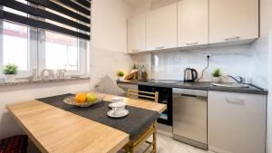 a kitchen with a table with a bowl of fruit on it at Terra Verde in Račički Brijeg +18 photos