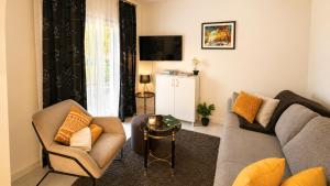 a living room with a couch and chairs and a tv at Terra Verde in Račički Brijeg