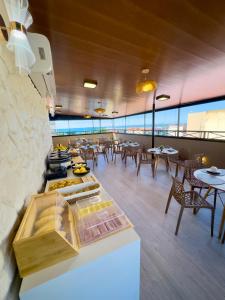 a restaurant with tables and chairs and a counter with food at Hotel Vistta Iracema in Fortaleza