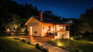 a small white house with a patio at night at Terra Verde in Račički Brijeg