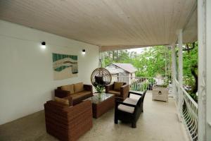 a screened in porch with a couch and chairs at Qiwi House in Ureki