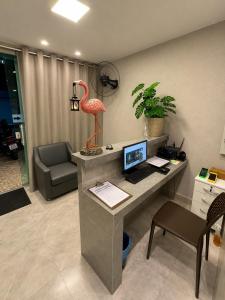 an office with a desk with a flamingo statue on it at Flamingo Beach Pousada in Cabo Frio