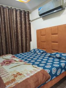 a bedroom with a bed and a television on the wall at Hotel Ravi Park Lahore in Lahore +3 photos