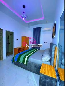 a bedroom with a bed and a purple ceiling at Meg Apartment in Asipa