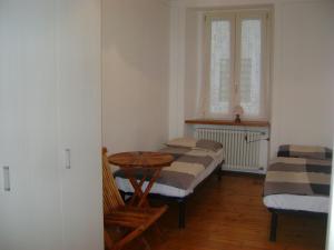 Cette chambre comprend 2 lits, une table et une fenêtre. dans l'établissement B&B Casa al Mulino, à Cannero Riviera