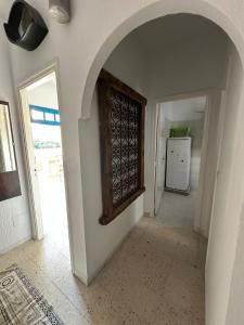 a hallway with an archway in a room with a refrigerator at Appartement henda 04 in Sousse