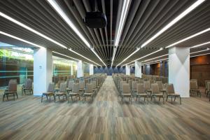 a row of chairs in a large room with wooden floors at Barcelo Guadalajara in Guadalajara