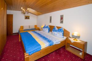 a bedroom with a large wooden bed with blue sheets at Appartement Hochleitner in Wagrain