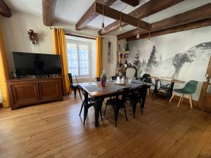 a dining room with a table and a tv at Murat - Le Duplex By Murat in Murat