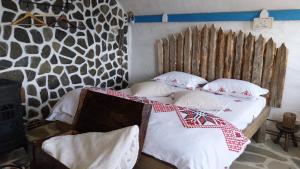 a bedroom with a bed with white sheets and pillows at Nook Hill in Comarnic