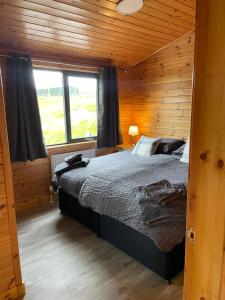 a bedroom with a bed in a wooden cabin at Shepherds Lodge in Shiel Bridge