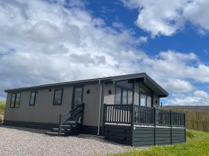 a mobile home with a porch and a staircase at Shepherds Lodge in Shiel Bridge