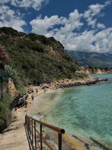 a beach with people on the sand and the water at Vouzianas home in Kefallonia