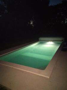 a swimming pool lit up at night at LES DAMES DE LA SAUGIAT in Le Fied