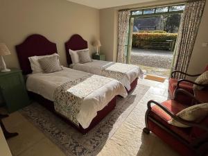 a bedroom with two beds and a door to a yard at Semeil Farm Holiday Lets in Strathdon