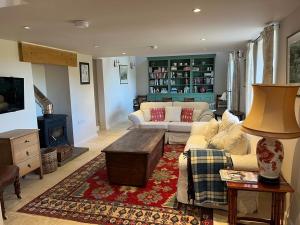 a living room with a couch and a table at Semeil Farm Holiday Lets in Strathdon