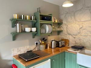 a kitchen with green cabinets and a counter top at Semeil Farm Holiday Lets in Strathdon