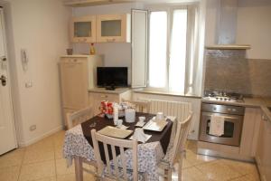 eine Küche mit einem Tisch und Stühlen sowie eine Küche mit einem Herd in der Unterkunft Sotto il Borgo Apartments in Iesi