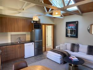 a living room with a couch and a kitchen at Resort Arrowtown in Arrowtown