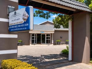 a building with a sign in front of it at Comfort e Casa Lodge Near OR Tambo Airport in Kempton Park +7 photos