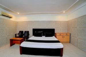 a bedroom with a bed and a table and chairs at Hotel O Meera in Chennai