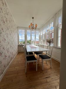 a dining room with a table and chairs and windows at Anders-Pers, The apartment downstairs in Järvsö