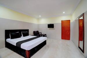 a bedroom with a bed and a television in it at Hotel O Meera in Chennai