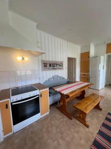 a kitchen with a table and a stove and a bench at Anders-Pers, The apartment downstairs in Järvsö +13 photos