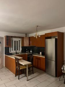 a kitchen with a table and a stainless steel refrigerator at Vouzianas home in Kefallonia