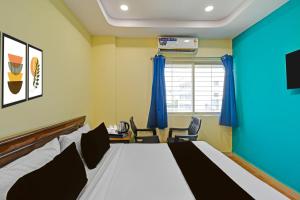 a hotel room with a bed and a table and chairs at HOTEL O MYRAA INN in Surūrnagar
