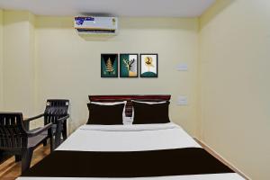 a bedroom with a bed and two chairs at HOTEL O MYRAA INN in Surūrnagar