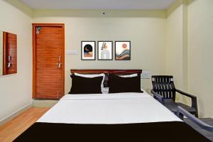 a bedroom with a large bed and a chair at HOTEL O MYRAA INN in Surūrnagar +25 photos
