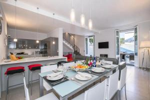 a dining room and kitchen with a table and chairs at Villa Lucia Laglio in Laglio