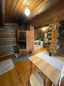 a living room with a table and a brick fireplace at Kangasjoki Riverside Camp in Suomussalmi