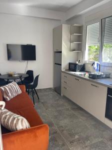 a living room with a couch and a kitchen at Durres Garden Stay in Durrës
