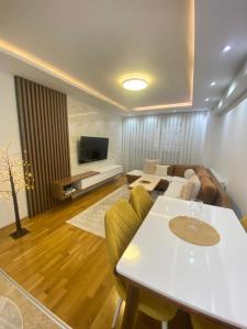 a living room with a table and a couch at AJ Apartments in Kosovo Polje