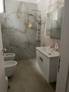 a bathroom with a sink and a toilet and a mirror at Durres Garden Stay in Durrës
