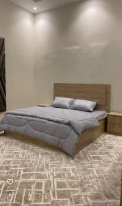 a large bed in a bedroom with a carpet at Aean partmrnt in Jeddah