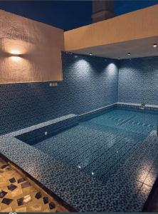 a large swimming pool in a building at night at Aean partmrnt in Jeddah