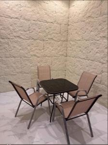 a table and two chairs and a table and a wall at Aean partmrnt in Jeddah