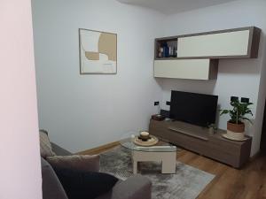 a living room with a couch and a tv at Da Ciro e Angela in Barolo