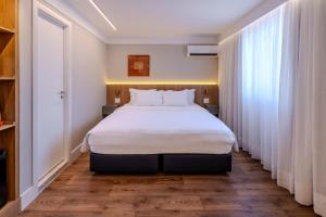 a bedroom with a large bed and a window at Intercity São Paulo Nações Unidas in São Paulo