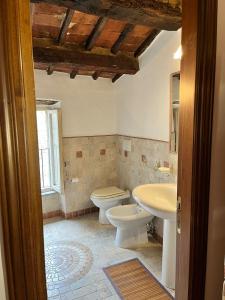 a bathroom with a toilet and a sink at La Casetta di Guido in Pitigliano +22 photos