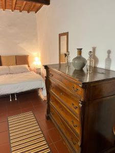 a bedroom with a wooden dresser and a bed at La Casetta di Guido in Pitigliano