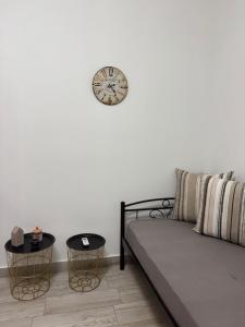 a living room with a couch and a clock on the wall at Dream Catcher3 in Agia Theodoti