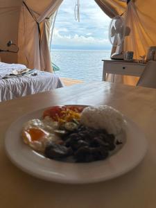 a plate of food with eggs on a table at Reef Resort - Mount Apo View Unit B4 in Kaputian