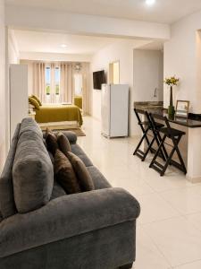 a living room with a couch and a kitchen at LEON MARIA HOSPEDAGENS - Smart Flat Hotel e Residence in Mogi das Cruzes