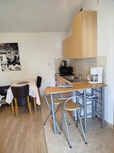 a small kitchen with a table and chairs and a sink at Pelivan Apartments in Kaštela