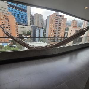 a balcony with a hammock in the middle of a city at Apartamento terraza hamaca - doble parqueadero - Provenza in Medellín